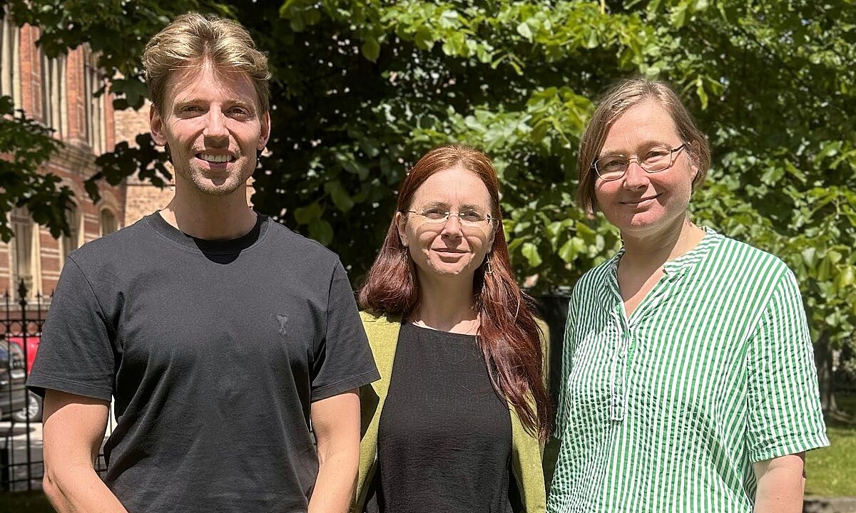 Drei Dozierende des Arbeitsbereichs stehen nebeneinander auf dem Gelände des Instituts.